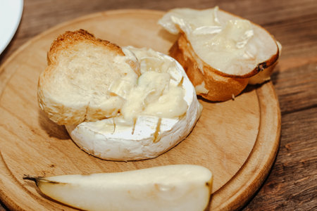 White baguette with olive oil and baked Camembert cheese on the table.の写真素材