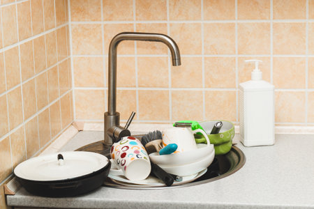 A pile of dirty dishes, cups, plates in the sink.の写真素材