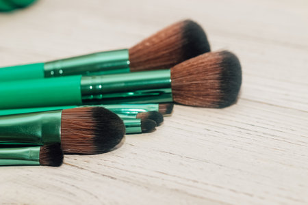 Green makeup brushes on a wooden table.の写真素材