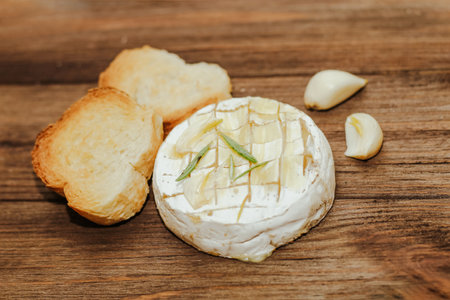 White baguette cut into pieces with olive oil and Camembert cheese on the table.の写真素材