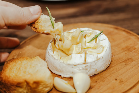 White baguette with olive oil and baked Camembert cheese on the table.の写真素材