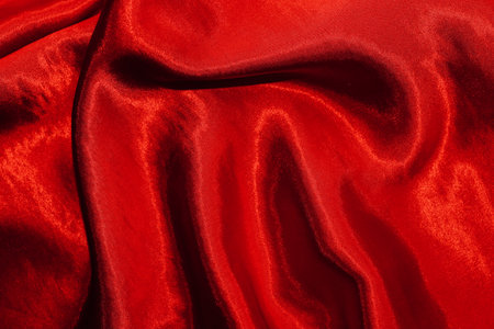 Red shiny texture of silk satin satin with folds.の写真素材
