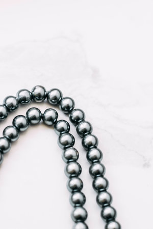 A necklace of gray beads on a white aesthetic background.の写真素材