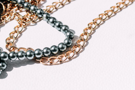 A necklace of gray beads with chain decorations on a white aesthetic background.の写真素材
