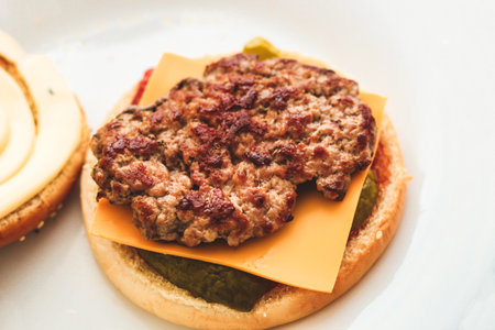 Buns for homemade burgers with ketchup and cutlet lie on a plate.の写真素材