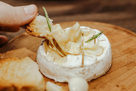 White baguette with olive oil and baked Camembert cheese on the table.の写真素材