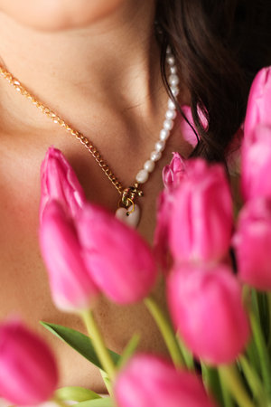 Close-up detail of beauty girl with jewelry and pink flowers sealsの写真素材