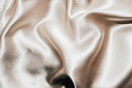 Golden shiny texture of silk satin satin with folds.の写真素材