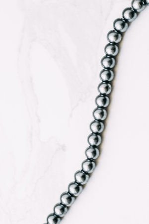 A necklace of gray beads on a white aesthetic background.の写真素材