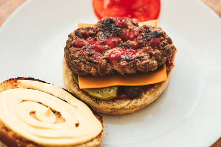 Buns for homemade burgers with ketchup and cutlet lie on a plate.の写真素材