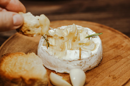White baguette with olive oil and baked Camembert cheese on the table.の写真素材