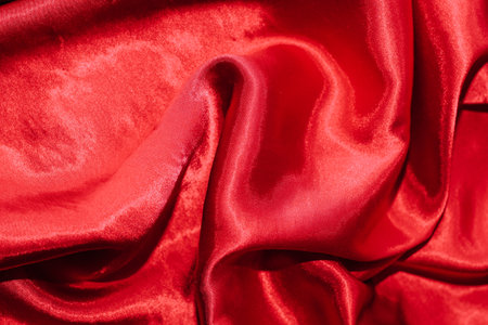 Red shiny texture of silk satin satin with folds.の写真素材
