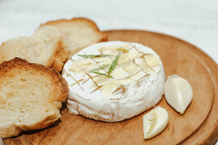 White baguette cut into pieces with olive oil and Camembert cheese on the table.の写真素材