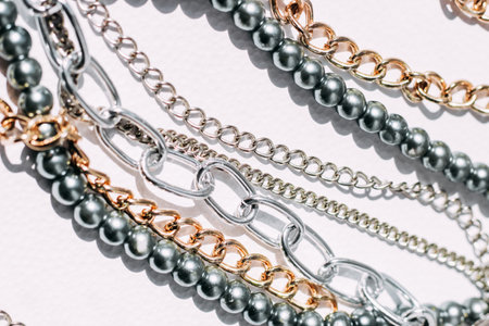 A necklace of gray beads with chain decorations on a white aesthetic background.の写真素材
