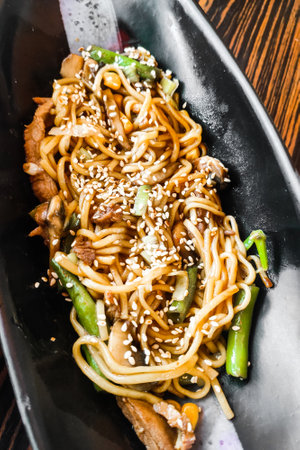Asian noodles with sesame and teriyaki in a plate close-up.の写真素材