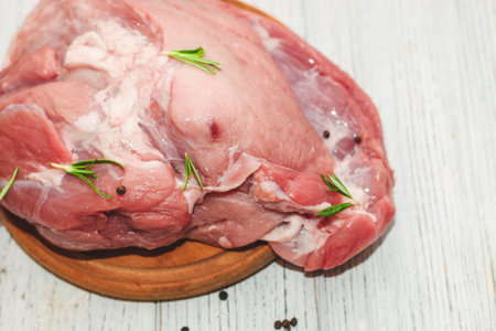 Fresh piece of meat large pork ham on a board with pepper.の写真素材