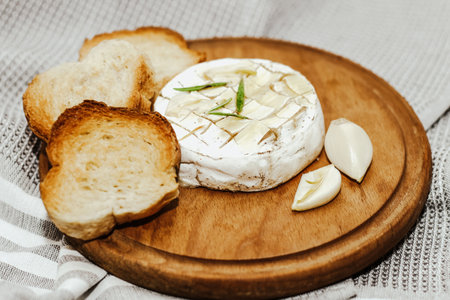 White baguette cut into pieces with olive oil and Camembert cheese on the table.の写真素材