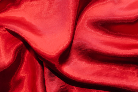 Red shiny texture of silk satin satin with folds.の写真素材