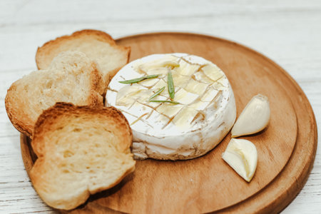 White baguette cut into pieces with olive oil and Camembert cheese on the table.の写真素材