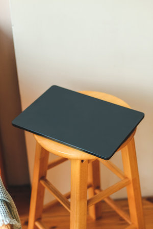 A thin laptop working computer stands on a stylish chair in the interior.の写真素材
