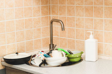 A pile of dirty dishes, cups, plates in the sink.の写真素材