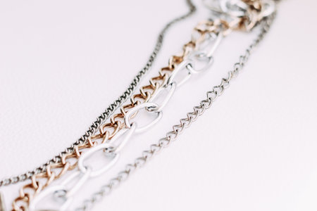 Gold and silver jewelry chains of different diameters on a white background.の写真素材