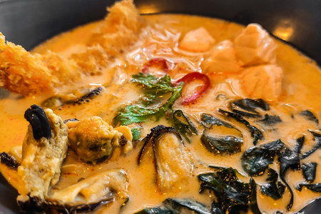Thai tom yum soup in a plate with seafood, seaweed close-up.の写真素材