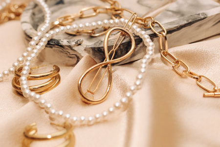 Women's jewelry, gold chain, trendy jewelry on a silk background.の写真素材