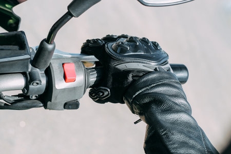 Protective moto gloves, safety gear close-up on brake handleの写真素材