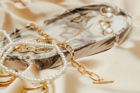 Women's jewelry, gold chain, trendy jewelry on a silk background.の写真素材