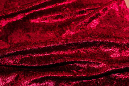 Texture of red velor corduroy fabric with folds.の写真素材