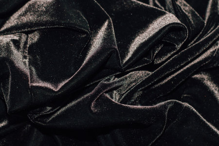 Texture of black velor corduroy fabric with folds.の写真素材
