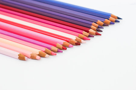Multi-colored pencils lie on a white table, the violet range of colors.の写真素材