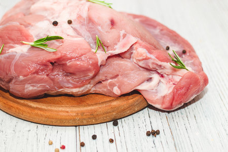 Fresh piece of meat large pork ham on a board with pepper.の写真素材