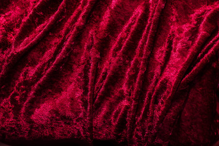 Texture of red velor corduroy fabric with folds.の写真素材