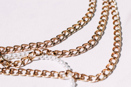 A necklace of white beads with chains of jewelry on a white aesthetic background.の写真素材
