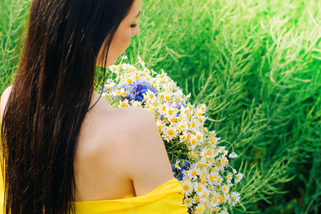 Portrait of a dark-haired girl with a bouquet of wild flowersの写真素材