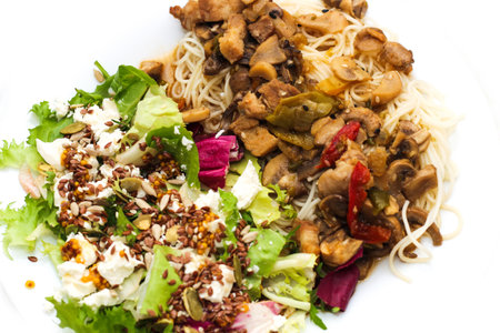 Thin wheat Asian noodles close-up with salad and stew.の写真素材