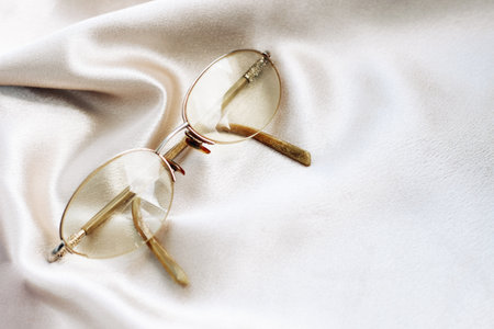 Glasses in a gold frame with diopters on a silk backgroundの写真素材