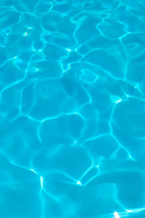 Azure transparent texture of water in a blue pool with splashes from the sunの写真素材