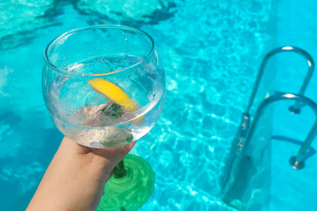 Cocktail with lemon tonic on blue pool backgroundの写真素材