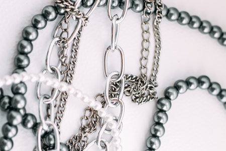 A necklace of gray beads with chain decorations on a white aesthetic background.の写真素材