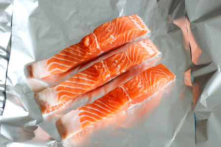 Sliced pieces of red sea salmon fish caught on foilの写真素材