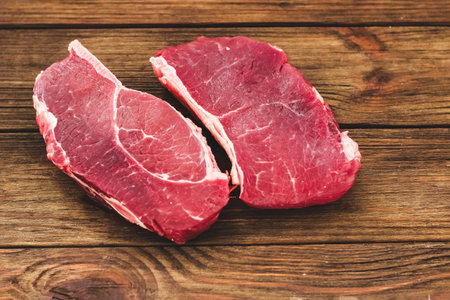 A piece of premium meat, striploin steak on a wooden tableの写真素材
