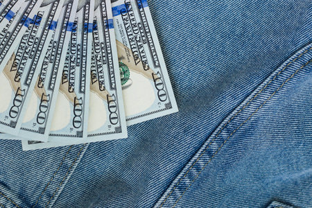 Bills of 100 dollars on a denim background in a pocket