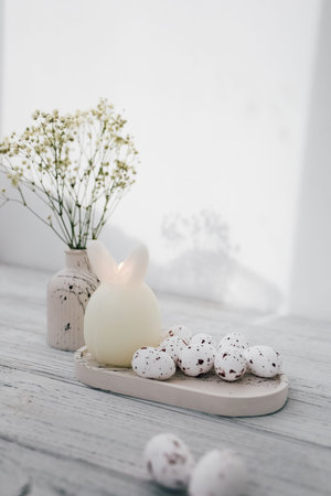 Soft pastel Easter decor featuring a spring arrangement and decorative eggs on a simple tableの写真素材