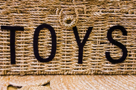 A bamboo basket labeled toys is neatly placed in a well-lit space, providing organization for...