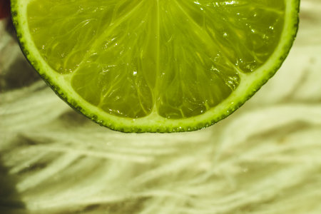 Close up of a freshly cut lime over light colored background showcasing its vibrant interiorの写真素材