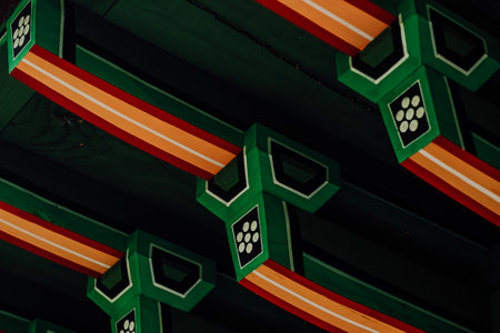Intricate wooden beams display vivid patterns and colors under the ceiling in a historic Korean structure showcasing artistry and cultural heritage.の写真素材