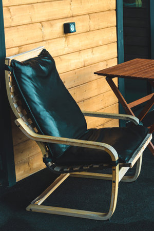 A cozy black lounge chair sits on a playful balcony perfectly positioned for enjoying warm sunbeams...